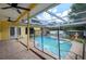 A pool area with a partial screen enclosure and covered patio at 17807 Fallowfield Dr, Lutz, FL 33549