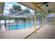 Backyard features a refreshing pool with a screened enclosure and tiled patio at 17807 Fallowfield Dr, Lutz, FL 33549