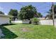 The backyard offers a spacious grassy area enclosed by a white fence at 1868 Lombardy Dr, Clearwater, FL 33755
