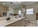 Bathroom featuring double sinks, an oversized mirror, wood-look accent tiles, and a window with blinds at 1868 Lombardy Dr, Clearwater, FL 33755