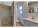 The bathroom features a tiled walk-in shower, a window, and a vanity sink with a mirror at 1868 Lombardy Dr, Clearwater, FL 33755