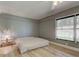 A bedroom with light gray walls, wood floors, a bed, and natural light coming through a window at 1868 Lombardy Dr, Clearwater, FL 33755