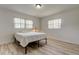 Simple bedroom design with light wood floors, a bed, and windows at 1868 Lombardy Dr, Clearwater, FL 33755