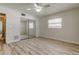 Bright bedroom features mirrored closet doors, a ceiling fan, wood-look floors, and a window with blinds at 1868 Lombardy Dr, Clearwater, FL 33755