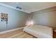 Cozy bedroom with gray walls and light wood floors and a decorative wall hanging at 1868 Lombardy Dr, Clearwater, FL 33755