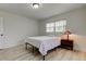 Bright bedroom featuring wood-look floors, a window with blinds, and a cozy bedside table with a lamp at 1868 Lombardy Dr, Clearwater, FL 33755