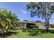 Charming single-story home with a manicured front lawn and a mature shade tree at 1868 Lombardy Dr, Clearwater, FL 33755