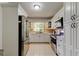 White kitchen with stainless steel appliances, stylish tile backsplash, and ample cabinet space at 1868 Lombardy Dr, Clearwater, FL 33755