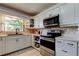 Bright kitchen with white cabinetry, stainless steel appliances, and a modern sink at 1868 Lombardy Dr, Clearwater, FL 33755