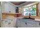 Well-lit kitchen featuring white cabinets, light countertops, and a dark, modern faucet at 1868 Lombardy Dr, Clearwater, FL 33755