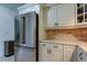 Kitchen area featuring stainless steel refrigerator, white cabinets, and light countertops at 1868 Lombardy Dr, Clearwater, FL 33755