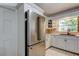 Well-lit kitchen features white cabinets and stainless steel refrigerator at 1868 Lombardy Dr, Clearwater, FL 33755