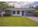 Charming single-story home with a blue front door, landscaped yard, and a well-maintained lawn at 1882 Maryland Ne Ave, St Petersburg, FL 33703