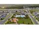 Aerial view of community pool, park, and modern homes near a highway in a green neighborhood at 19272 Blue Pond Dr, Lutz, FL 33558