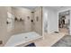 Modern bathroom features a glass-enclosed shower with neutral tile and a view to the commode room and walk-in closet at 19272 Blue Pond Dr, Lutz, FL 33558