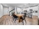 Dining area featuring a wooden table, black chairs, and an open view to the kitchen and staircase at 19272 Blue Pond Dr, Lutz, FL 33558