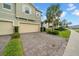 View of the townhome with a stone paver driveway and lush green landscaping at 19272 Blue Pond Dr, Lutz, FL 33558