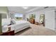 Bright main bedroom features a large bed, tray ceilings, a window with natural light, and a TV at 19272 Blue Pond Dr, Lutz, FL 33558