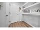 Functional mudroom with storage shelves, door, and wood-look flooring at 19272 Blue Pond Dr, Lutz, FL 33558