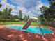Relaxing backyard pool featuring a slide and well-maintained red brick patio at 2014 Nancy Ave, Lutz, FL 33548