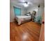Bedroom with hardwood floors, queen bed, unique hammock chair, and ample space at 2014 Nancy Ave, Lutz, FL 33548