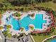 Aerial view of a community pool featuring a slide, lap lanes, and ample seating with palm tree landscaping at 20244 Merry Oak Ave, Tampa, FL 33647