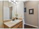 Bright bathroom with a single sink vanity, neutral countertops, and a large mirror at 20244 Merry Oak Ave, Tampa, FL 33647