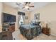 Well-lit bedroom with a ceiling fan, TV, and dark wood furnishings at 20244 Merry Oak Ave, Tampa, FL 33647