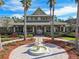 Welcoming clubhouse exterior with fountain, palms, and lush landscaping under a bright blue sky at 20244 Merry Oak Ave, Tampa, FL 33647