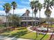Clubhouse exterior featuring an American flag, lush landscaping, and a picturesque fountain at 20244 Merry Oak Ave, Tampa, FL 33647