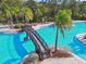 Community pool featuring a bridge, lounge chairs, and mature landscaping at 20244 Merry Oak Ave, Tampa, FL 33647