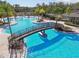 Aerial view of the community pool featuring a bridge, lounge chairs, and lush landscaping at 20244 Merry Oak Ave, Tampa, FL 33647