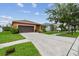 Charming single-story home featuring a well-manicured lawn, and an attached two-car garage and long driveway at 20244 Merry Oak Ave, Tampa, FL 33647