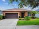 Charming single-story home featuring a well-manicured lawn, and an attached two-car garage and sidewalk at 20244 Merry Oak Ave, Tampa, FL 33647