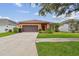 Charming single-story home featuring a well-manicured lawn, and an attached two-car garage and sidewalk at 20244 Merry Oak Ave, Tampa, FL 33647