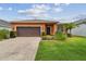 Charming single-story home featuring a well-manicured lawn, and an attached two-car garage and sidewalk at 20244 Merry Oak Ave, Tampa, FL 33647