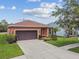 Charming single-story home featuring a well-manicured lawn, and an attached two-car garage and long driveway at 20244 Merry Oak Ave, Tampa, FL 33647