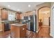 Well-lit kitchen with granite countertops, stainless steel appliances, an island, and hardwood floors at 20244 Merry Oak Ave, Tampa, FL 33647
