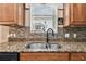 Stainless steel sink with granite countertops and mosaic tile backsplash in a well-lit kitchen at 20244 Merry Oak Ave, Tampa, FL 33647