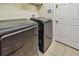 Modern laundry room with gray washer and dryer set and tile flooring at 20244 Merry Oak Ave, Tampa, FL 33647