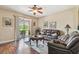 Comfortable living room with hardwood floors, ceiling fan, and sliding glass doors to the outdoor area at 20244 Merry Oak Ave, Tampa, FL 33647