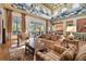 Open-concept living room with hardwood floors, decorative pineapple trim, comfortable seating, and lots of light at 20244 Merry Oak Ave, Tampa, FL 33647