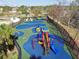 Aerial view of a fenced community playground with slides, swings, and colorful play equipment on a green and blue surface at 20244 Merry Oak Ave, Tampa, FL 33647