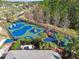 Aerial view of a fenced community playground with slides, swings, and various play equipment in a wooded area at 20244 Merry Oak Ave, Tampa, FL 33647