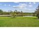 Scenic view of lush green lawn extending to a tranquil pond on a sunny day at 20244 Merry Oak Ave, Tampa, FL 33647