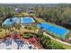 A top-down shot showcasing well-maintained tennis courts surrounded by lush greenery, offering a vibrant sports community at 20244 Merry Oak Ave, Tampa, FL 33647