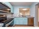 Charming kitchen with blue cabinetry, stainless appliances and pass through to living area at 2066 Sun Down Dr, Clearwater, FL 33763