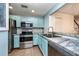 Modern kitchen featuring stainless steel appliances, a stylish backsplash, and blue cabinetry at 2066 Sun Down Dr, Clearwater, FL 33763