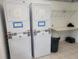 Well-maintained community laundry area with stacked dryers, a folding table, and storage space for added convenience at 221 Fernwood Cir # 221, Seminole, FL 33777