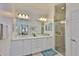 Bathroom featuring double sinks, shower, and white cabinetry at 2292 Sifield Greens Way # 59, Sun City Center, FL 33573